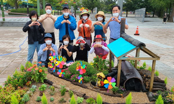 탄현동 주민자치위원들과 관계자들이 참여정원 앞에서 함께 자리했다.