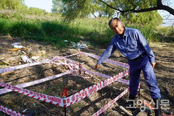 대덕생태공원 한강수변에서 지뢰를 발견한 한국지뢰제거연구소 김기호 소장이 지뢰가 있던 자리를 가리키고 있다. 