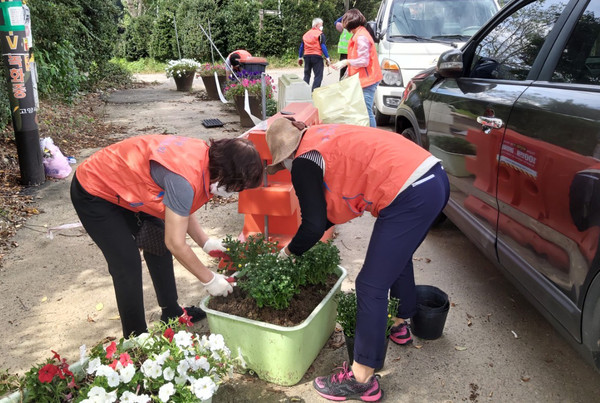 원신동 주민자치위원들이 화분에 꽃을 식재하고 있다.