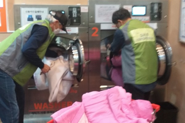  성사1동 지역사회보장협의체 위원들이 사랑나눔 세탁지원사업을 하고 있다.