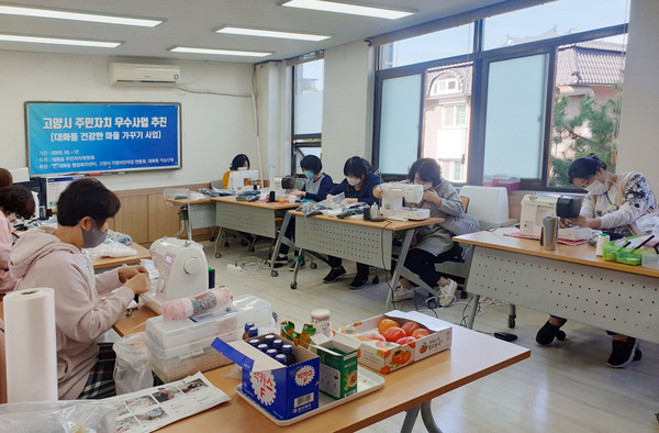 대화동이 고양시가정어린이집연합회와 새담공동체 등 봉사자들이 동참한 가운데 마스크를 만들고 있다.