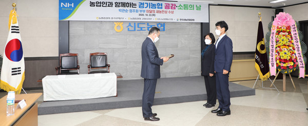 김장섭 농협중앙회 경기지역본부장으로부터 상을 받고 있는 박관순 엄주화 부부.