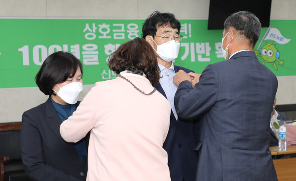 홍응유 한국새농민회 경기도지회장 부부가 새농민상과 관련한 뱃지를 달아주고 있다.