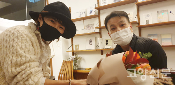 서울 목동에서 온 한 독자가 윤동희 작가에게 꽃을 선물하고 있다.