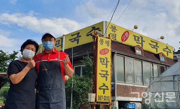봉평고향막국수 앞에서 유숙열 장석윤 대표가 포즈를 취하고 있다.
