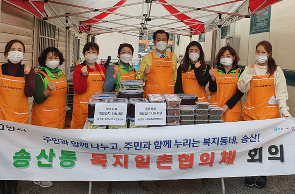 송산동 지역사회보장협의체가 계절김치와 밑반찬 나눔에 앞서 화이팅 하고 있다.