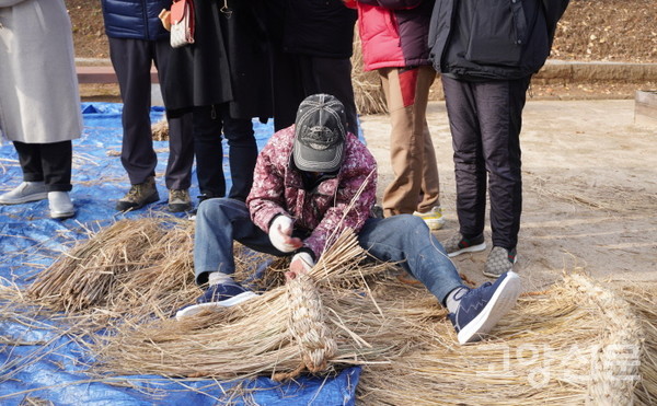 초가지붕 전통기술보유자가 짚을 이용해 용마름을 엮고 있다. 