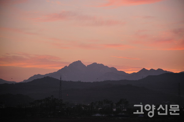 노고산 너머로 바라본 북한산의 일출. 하늘을 향해 우뚝 솟은 북한산은 고대로부터 오늘날에 이르기까지 한강 하구 평야지대에 사는 사람들의 마음속에 상서롭게 자리한 상징경관이다. [사진=이재용 사진작가]