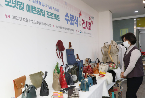 김주실 노동복지나눔센터 이사장이 수료생들의 전시작품을 감상하고 있다.