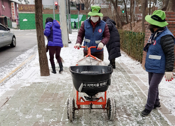  이른 아침 일찍부터 제설 작업을 하고 있는 성사2동 제설봉사단과 주민들.