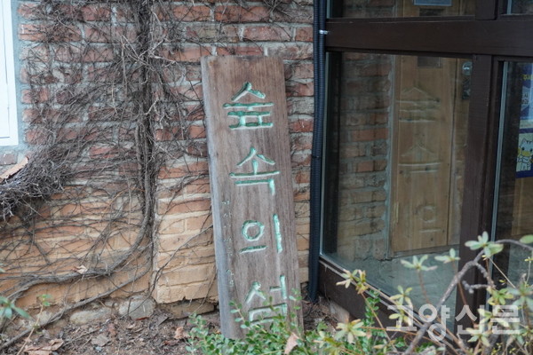 '백마 화사랑'이라고 명명된 건물 입구 뒤편 정원에 덩그러니 놓여진 숲속의 섬 나무 간판. 공간이 지나온 원래의 이름과 시간을 되살리는 것이 '상징건축물 지정'의 첫 단추가 아닐까. 