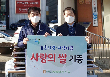 신도농협 김한모 조합장(오른쪽)이 화전동에 사랑의 쌀을 기증하고 있다.