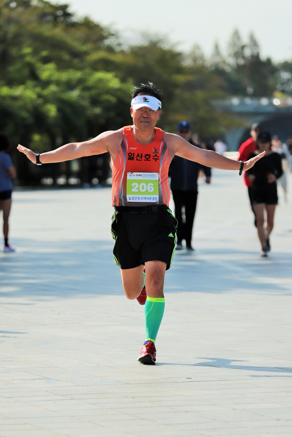 한승기씨는 마라톤 대회에서 골인할 때 항공기 날개 모습을 하고 골인한다.