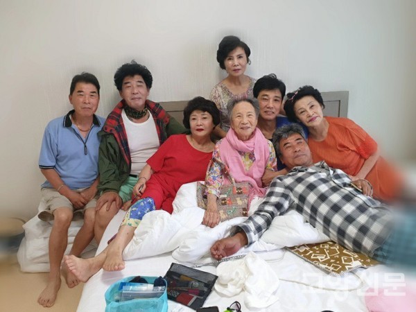 핑크색 목도리를 한 어머니 주위로 효자효녀들이 정다운 모습으로 빙둘러 있다.