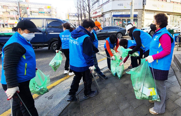  거리를 돌며 구석구석을 청소하고 깨끗한 거리를 만드는 성사1동 주민자치위원회와 주민들.