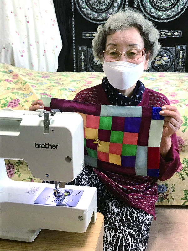 직접 만든 조각보를 들고 있는 어르신. 아직도 밤늦도록 재봉틀로 소품을 만든다.