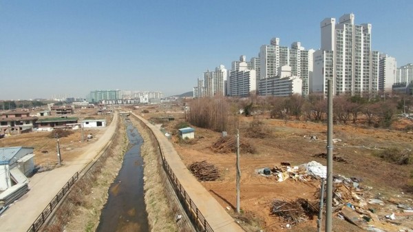 ▲ 올해 하반기 착공을 앞두고 있는 풍동2지구 1·2블럭 부지(백마교에서 바라본 모습). 풍동천 왼쪽으로는 오피스텔이 오른쪽으로는 아파트가 들어선다. 풍동천은 수변공원으로 개발된다. 