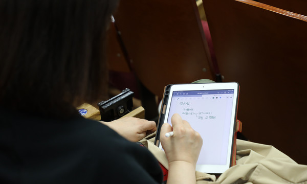 태블릿컴퓨터에 일산팜 온라인 설명회를 메모하고 있는 한 참가자.