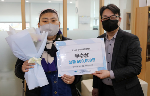 이미자님(우수상)에게  황재필 홀트수영종합사회복지관장(오른쪽)이 우수상과 상금을 전달하고 있다.