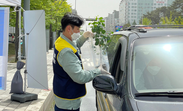 일산서구청 앞에서 있었던 고양 드라이브스루 플라워마켓에서 관계자가 고객에게 꽃을 전달하고 있다.