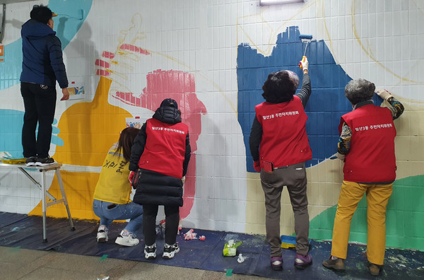 시민들에게 미적인 감각의 공간을 제공하기 위해 일산역 지하차도에 벽화를 그리고 있는 주민자치위원들.