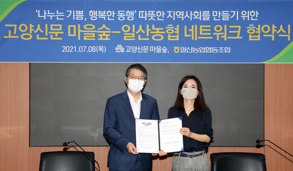 김진의 일산농협 조합장(왼쪽)과 이영아 고양신문 마을숲 대표(오른쪽)가 협약서에 서명후 나란히 자리했다.