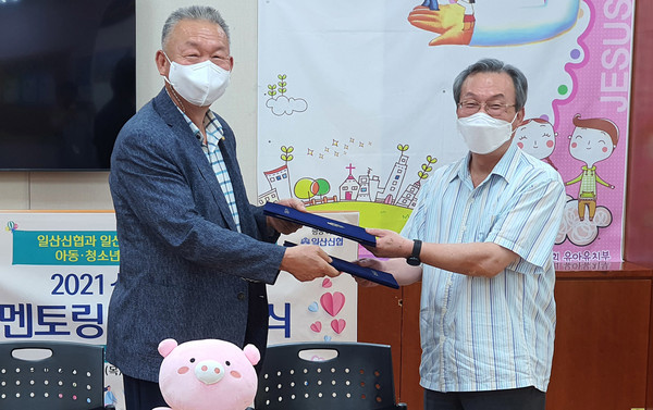 김병곤 일산신협 이사장(왼쪽)과 곽장준 일산지역아동센터 대표(오른쪽)가 협약서를 교환하고 있다.