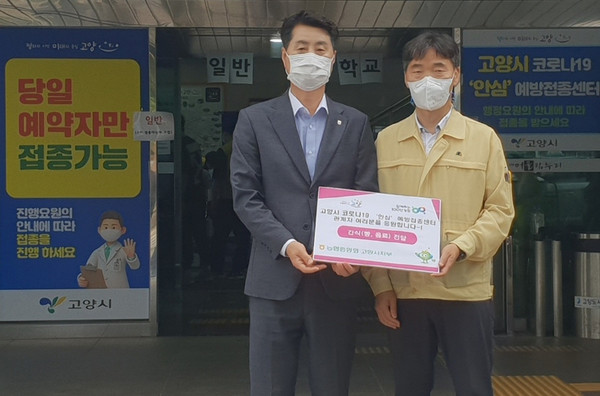  김재득 농협 고양시지부장(왼쪽)이 전남 무안군에서 생산된 햇양파로 만든 양파빵을 고양시예방접종센터에 전달하고 있다.