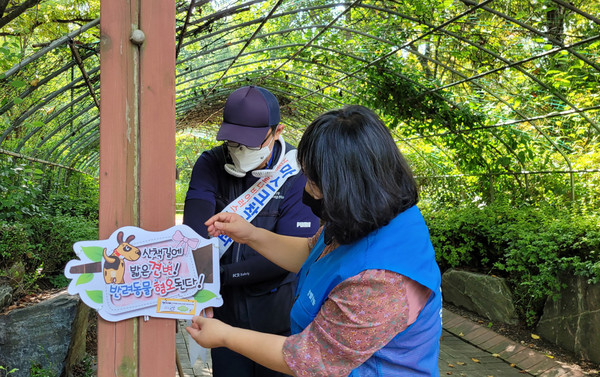 정발산동 직능단체와 관계자가 성숙한 반려문화 정착을 위해 꼼꼼하게 피켓을 부착하고 있다
