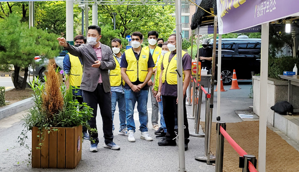 일산동구 보건소 조재원 팀장이 이민자들에게 선별진료소 사용방법을 안내하고 있다.