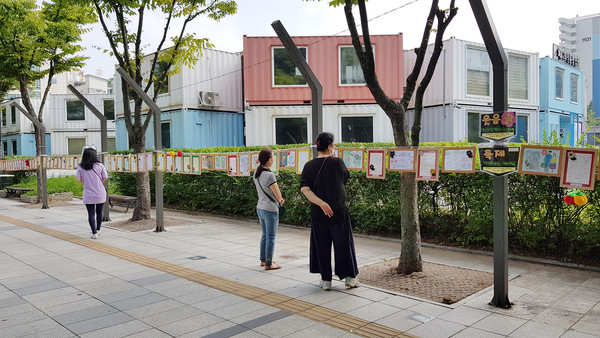 시화전이 열리는 길거리를 지나는 시민들은 발길을 멈추고 시를 읽고 있다.