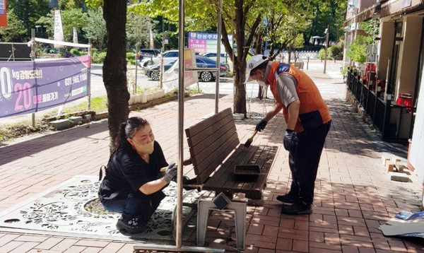 오랫동안 햇빛과 바람, 눈과 비에 노출돼 탈색이 된 벤치에 도색을 하고 있는 식사동 주민자치회 위원들.