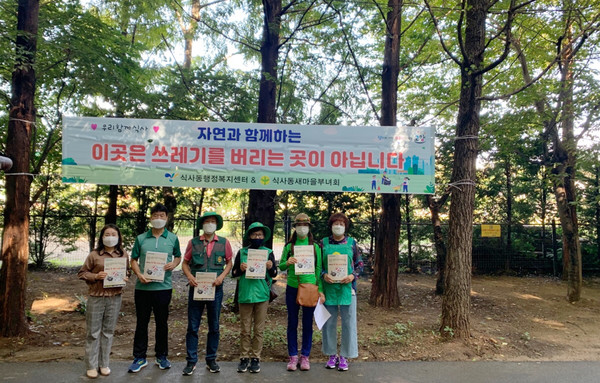 영글이산 입구에 현수막을 게시해 시민들의 참여를 유도하고, 주차된 차량 주변으로 쓰레기 무단투기 금지 홍보 전단지를 배한 식사동 새마을부녀회.