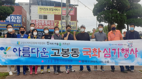 고봉동 주민자치위원회 주관으로 고봉동 대로변 유휴지에 국화를 식재한 고봉동 관계자들.