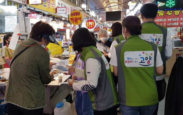 원당재래시장에서 성사1동 지역사회보장협의체가 위기가구 발굴을 위한 캠페인을 펼치고 있다.