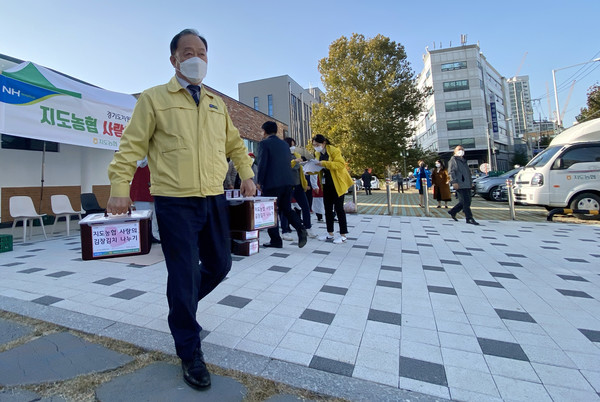 장순복 지도농협 조합장이 각 동에 전달될 김장김치를 나르고 있다.