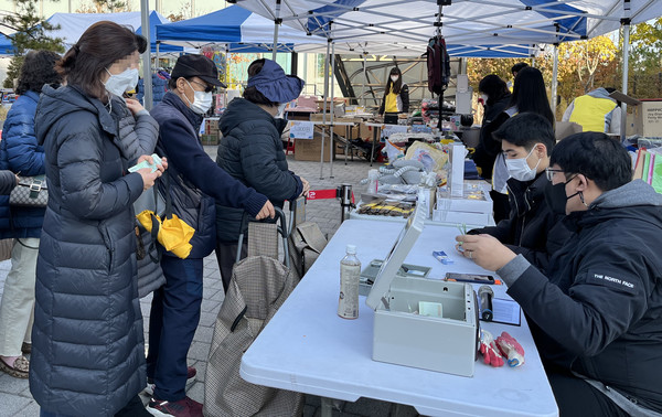 가성비 좋은 물품들로 구성된 바자회에서 주민들이 물품을 구매하고 있다.