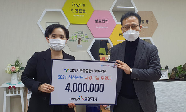 심재경 고양시흰돌종합사회복지관장이 KT&G 북서울본부로부터 사랑나눔 후원금을 전달받고 있다.