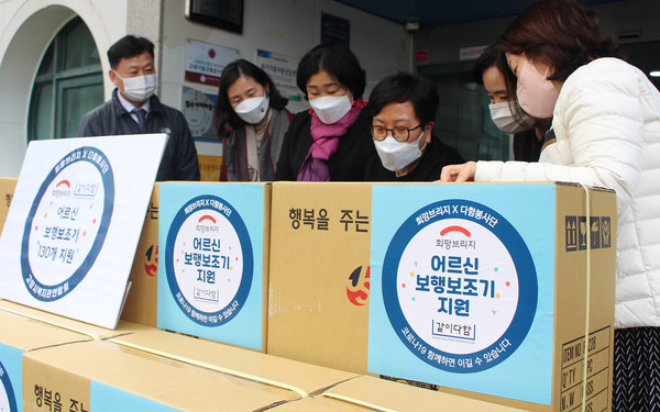  전달식에 참석한 관계자들이 보행보조기에 대해 이야기하고 있다.