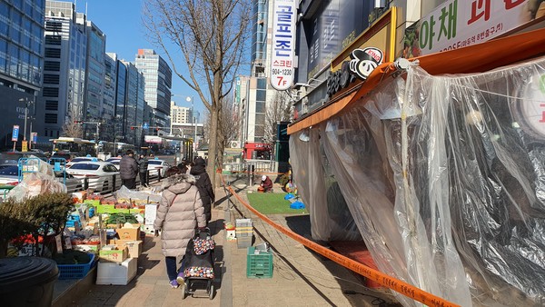 해당 상가건물에 입주한 한 과일가게는 과일과 채소를 길가에 내놓고 좌판을 벌이면서 영업을 이어가고 있다.
