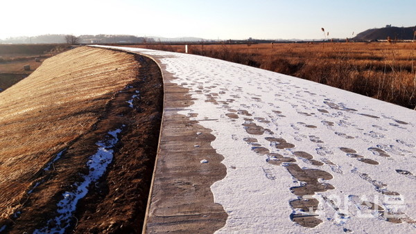 확장된 둑마루를 뒤덮은 시멘트 도로.