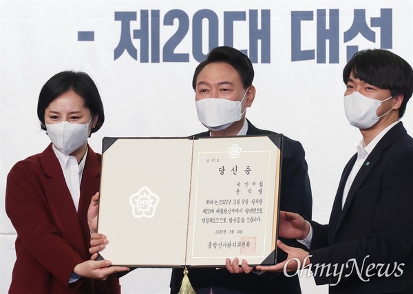 윤석열 대통령 당선인이 10일 오후 서울 여의도 국회 도서관에서 열린 국민의힘 대선 선거대책본부 해단식에서 중앙선거관리위원회로부터 받은 당선증을 청년보좌역에게 전달 받고 있다. ⓒ오마이뉴스 유성호