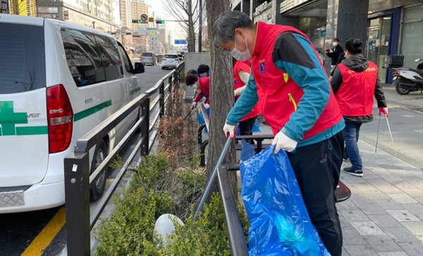 마을 구석구석을 청소하고 있는 성사1동 직능단체 회원들.
