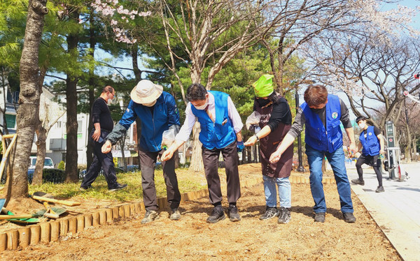 정발산동 주민자치회가 밤가시2공원 텃밭에 꽃씨를 뿌리고 있다.