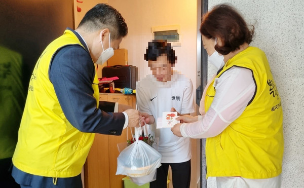 정발산동 지역사회보장협의체가 지역의 취약가구에 찾아가 카네이션 화분과 감사편지를 전달하고 있다.