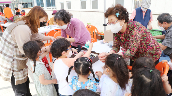 행사장을 찾은 아이들이 어르신들과 함께 만들기 체험을 하고 있다.