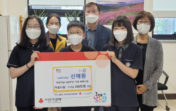 신애원이 바자회에서 마련된 수익금을 창릉동에 전달하고 있다.