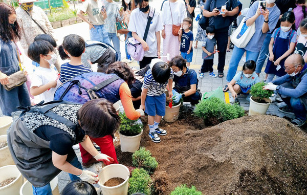 초화를 식재하고 있는 흥도동 관계자와 학생들.