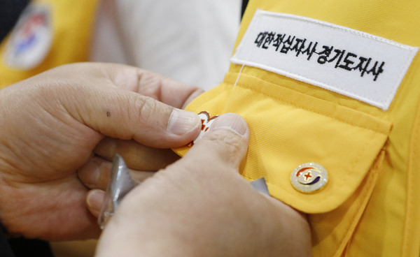 고양가좌봉사회에 적십자 배지를 달아주고 있는 적십자사 관계자들.