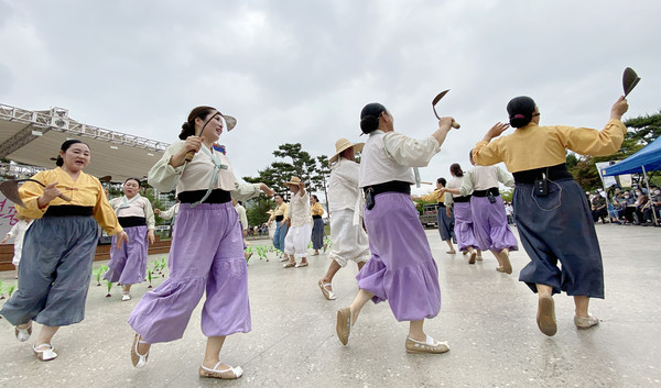 호미를 들고 공연하며 옛농사 풍경을 재현하고 있다